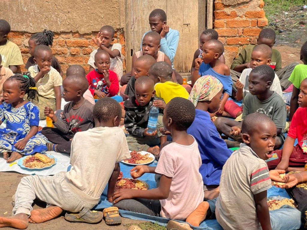 Children sitting on mats sharing a meal
