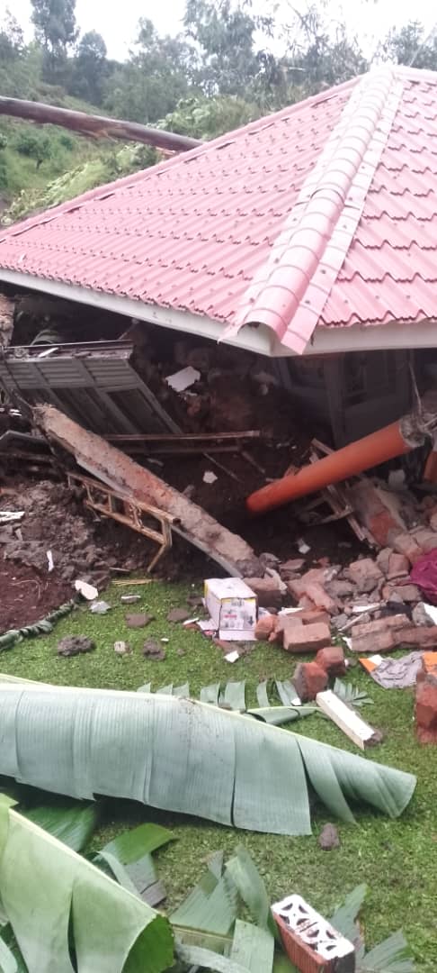 A house with a red roof collapsed into rubble