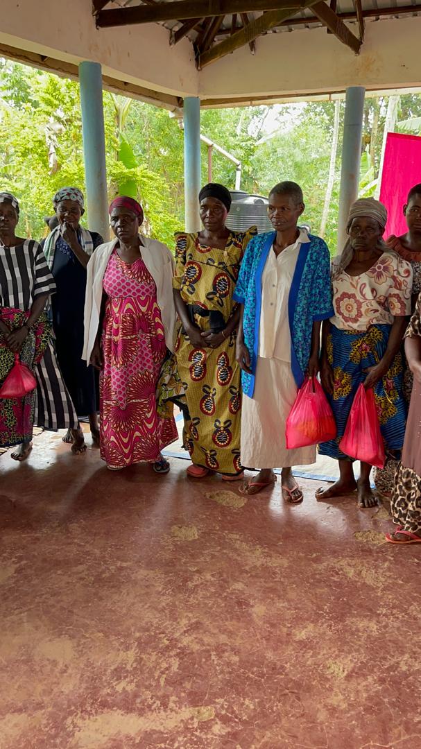Women from the community standing together under an open-sided shelter