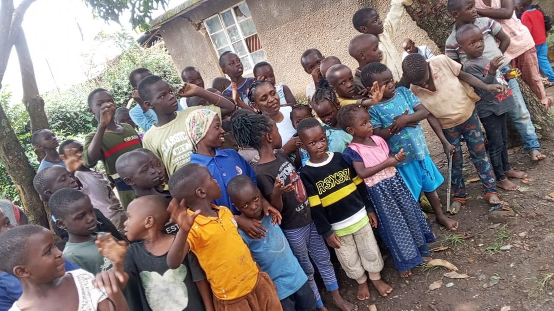 A long line of children waiting for a meal outside a house