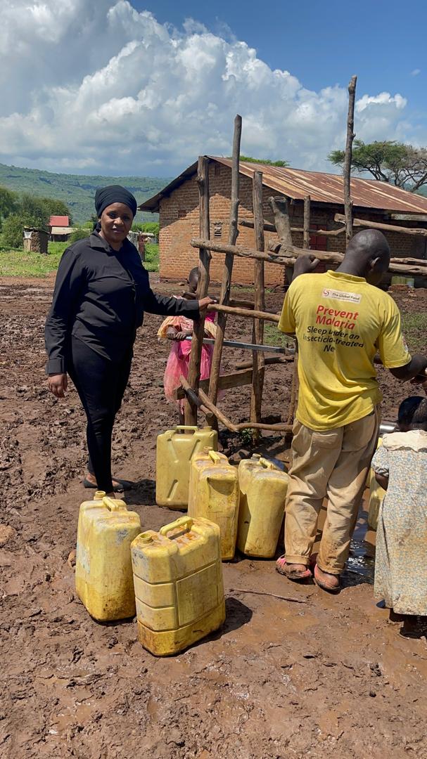 Projects 4 Staff at a water point with a row of yellow jerrycans