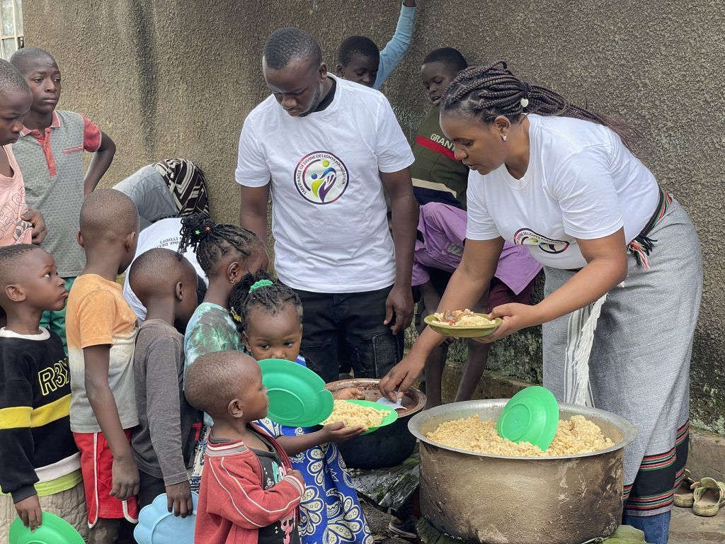 TDD Foundation volunteers dishing out food from a large pot to children