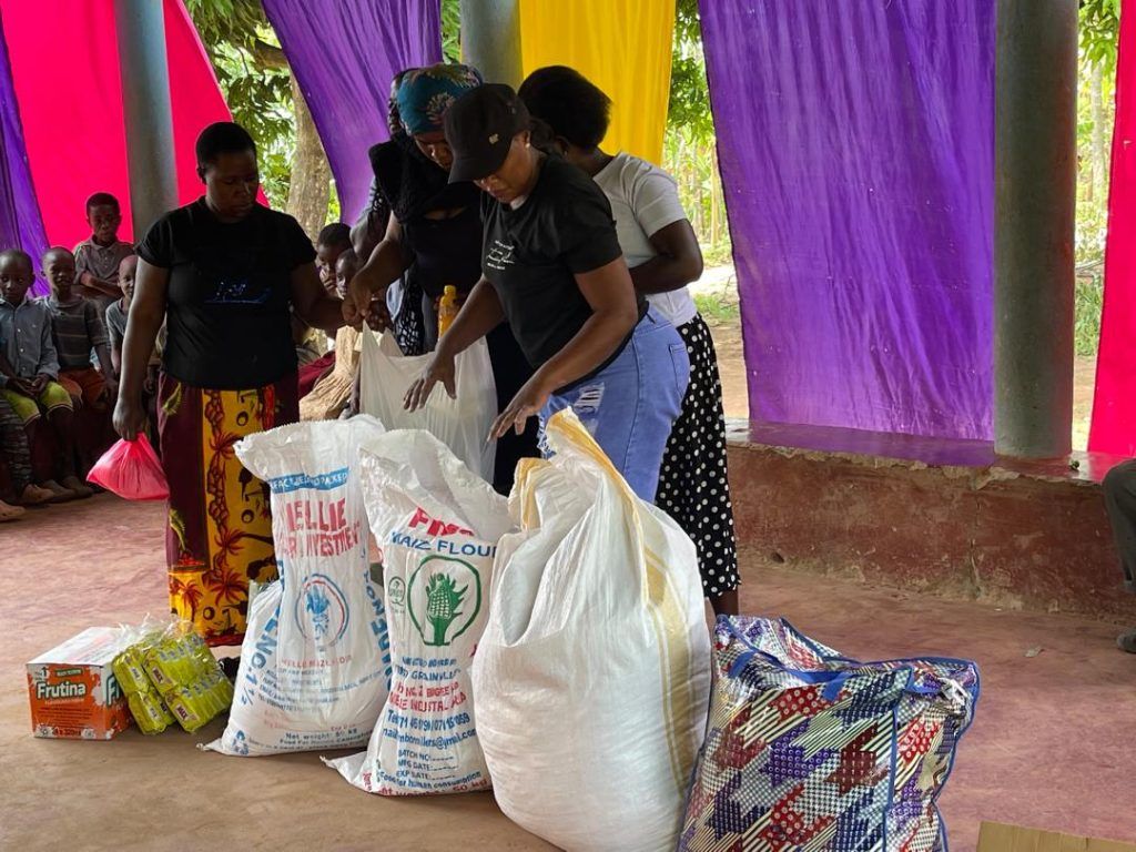 Volunteers handing out sacks of flour and food supplies to families